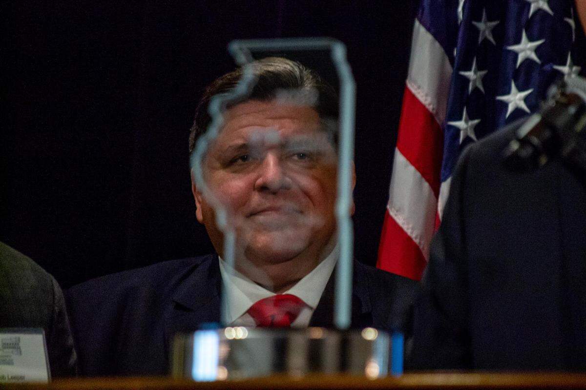 Gov. JB Pritzker is pictured through the 2022 Makers Madness trophy which is awarded by the Illinois Manufacturers’ Association to the “Coolest Thing Made in Illinois.”
