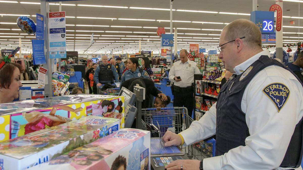 O’Fallon Police Chief Eric Van Hook assists with a holiday purchase during the annual Cops and Kids event at O’Fallon Wal-Mart last Christmas.