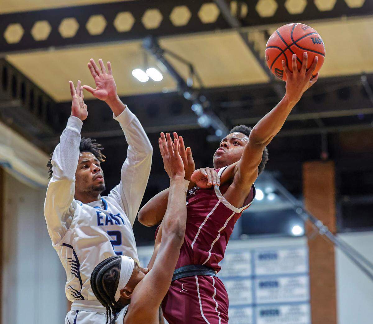 Belleville West’s Jordan Lacey shoots the ball against two Belleville East defenders during the Chick-fil-A Classic championship game. The Maroons ultimately fell to the Lancers 57-52.