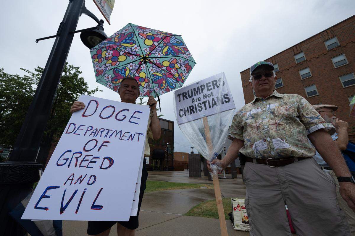 David Hoffmann (left) and Joe Yoch hold up signs at a protest in Belleville. Hoffmann and Yoch don’t relish the idea of protesting, and said they’ve only started coming out in recent years. “I’m 78 f—ing years old,” Hoffmann said, “I have better things to do.”