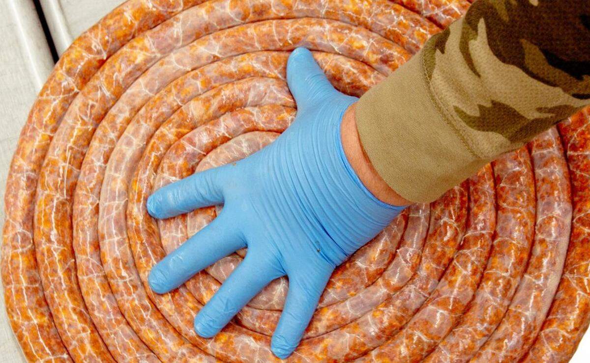 Juan Mena, 63, of Fairmont City, wraps chorizo stuffed in a casing that will later be twisted into links on Dec. 23 at the village community center in Fairmont City.
