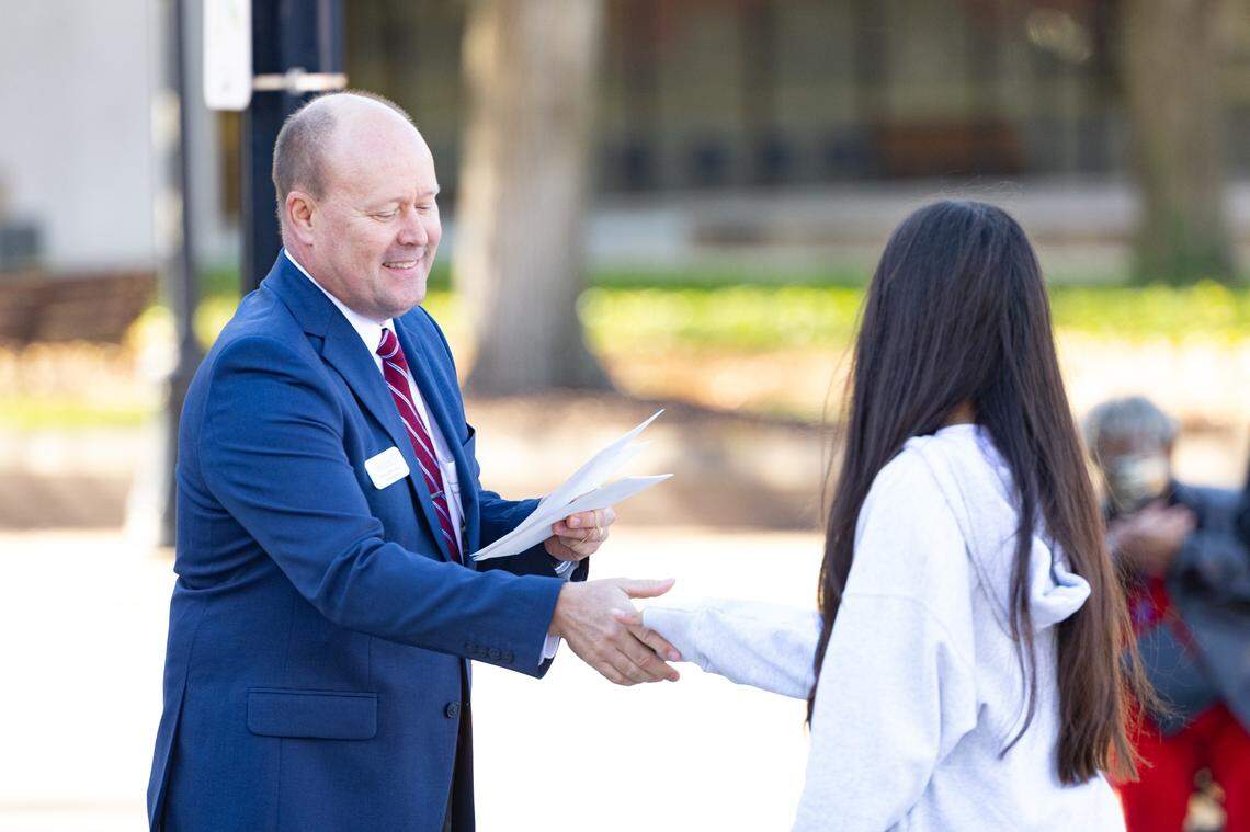 St. Clair County board chairman Mark Kern shakes hands with an essay contest winner during Belleville’s 26th annual Veterans Day ceremony on Nov. 11, 2024.
