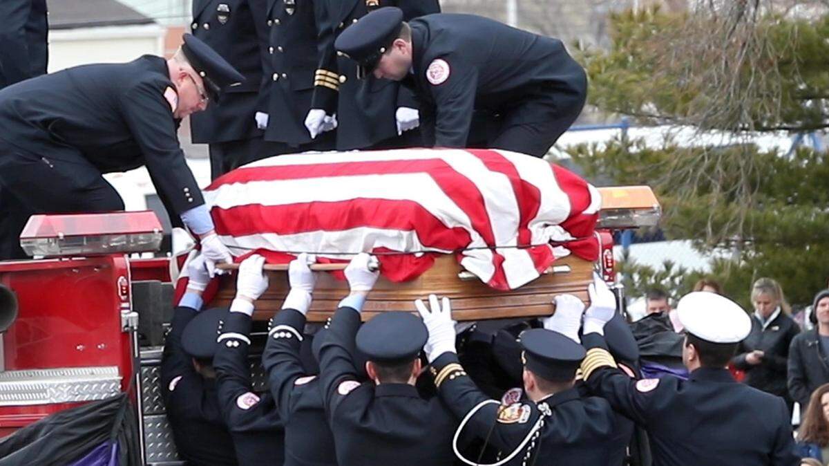 Firefighters place the casket carrying Capt. Jacob “Jake” Ringering of the Godfrey Fire Protection District into the back of a fire truck.  Hundreds turned out to mourn the loss of the Godfrey fire captain who died a week ago fighting a house fire in Bethalto.