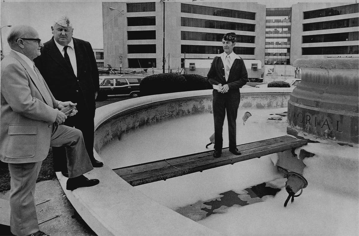 Pranksters filled the fountain with soap on the day of a check presentation. Veterans Screening Council Commander Oliver Tolin (center) and secretary-treasurer Walter Bien (right) presented a $3,400 check for Veterans Memorial Fountain renovations to city treasurer Homer Liebig (left).