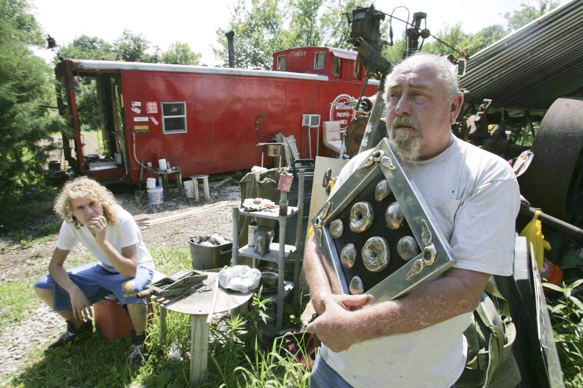Kenny Euge holds a piece of his artwork as his son Dominic looks on. 

photo by Zia Nizami