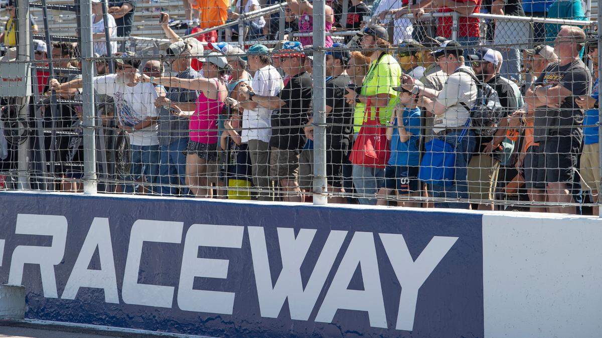 NASCAR fans gather near the track to get a photo of all the drivers lined up for a photo to promote the NASCAR Cup Series Enjoy Illinois 300 at World Wide Technology Raceway.