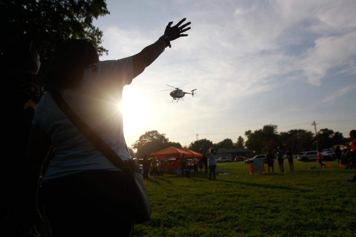 Burttina Henson waves at a helicopter as it takes off from Lincoln Park in East St. Louis on Aug. 1, 2023. The helicopter, piloted by officers from St. Louis County and St. Louis Metro police departments, was part of the city’s plan to help bridge the gap between the local community and law enforcement.