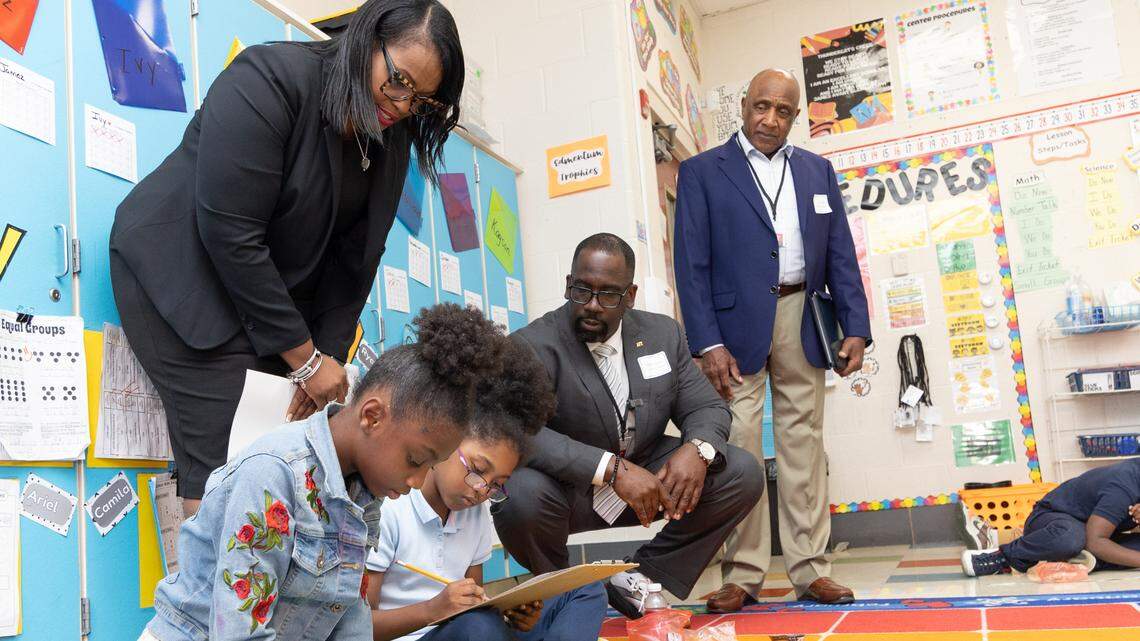 Avant Elementary School Principal Quanshanda Nicholson (left), American Federation of Teachers Secretary-Treasurer Fedrick Ingram (center) and East St. Louis Federation of Teachers President Terry Turley (right) observe children practicing group math exercises at Avant Elementary in Washington Park, Ill., on Oct. 8, 2024.