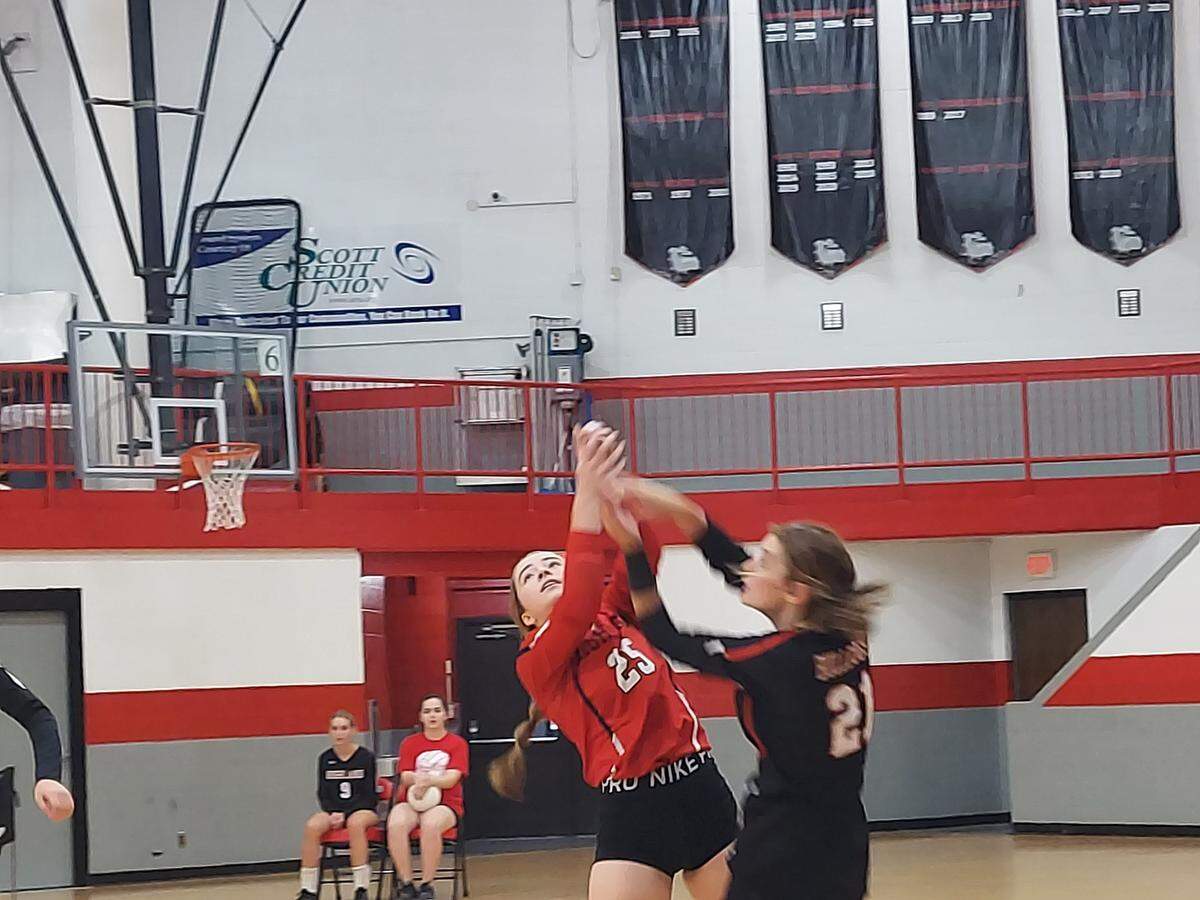 Highland’s Ally Russo (25) and Emmy Ernst (21) combine to return a volley over the net in the Lady Bulldogs 2022 season opener against Collinsville on Thursday, Aug. 25, at Highland High School. HHS came out focused from the outset and methodically took down the Kahoks in two games — 25-18, 25-18.