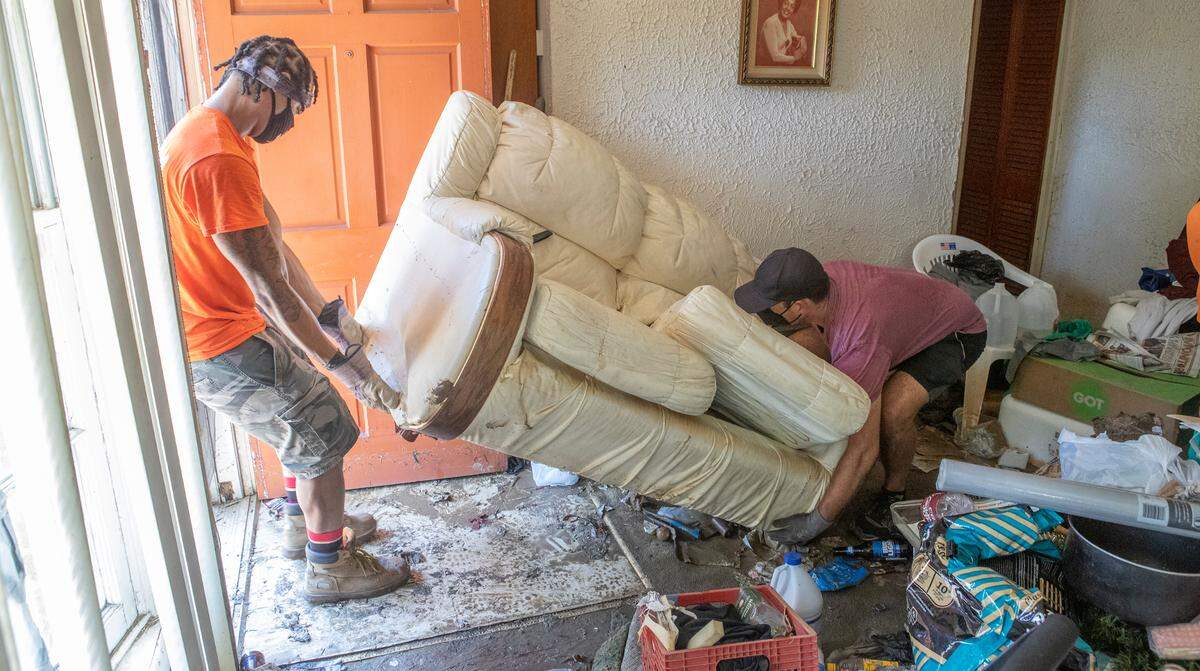 JD Dixon and Kyle Mayberry work to remove a couch that was saturated with flood water. The volunteers with Empire 13 and We Are The People STL removed furniture, carpet, and other items from East St. Louis homes that were flooded.