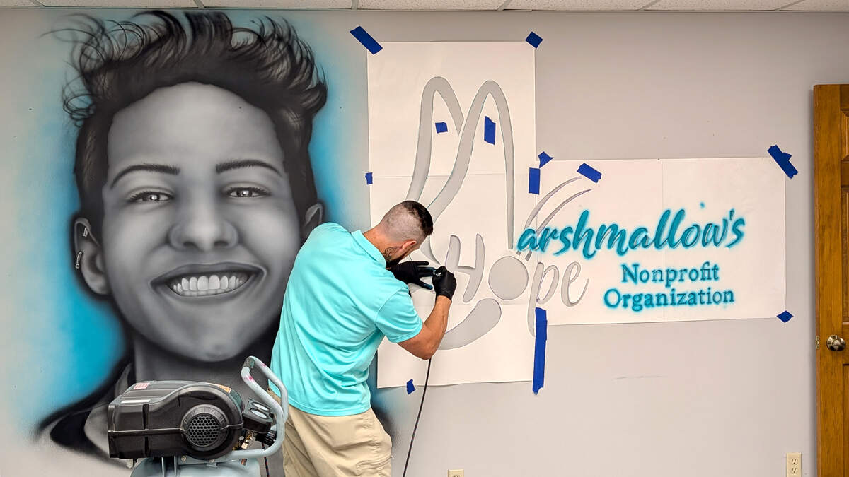 Ryan Robison of The Art Asylum Tattoo Studio paints a mural featuring Zachary Birkholz at Marshmallow's HOPE in Belleville.