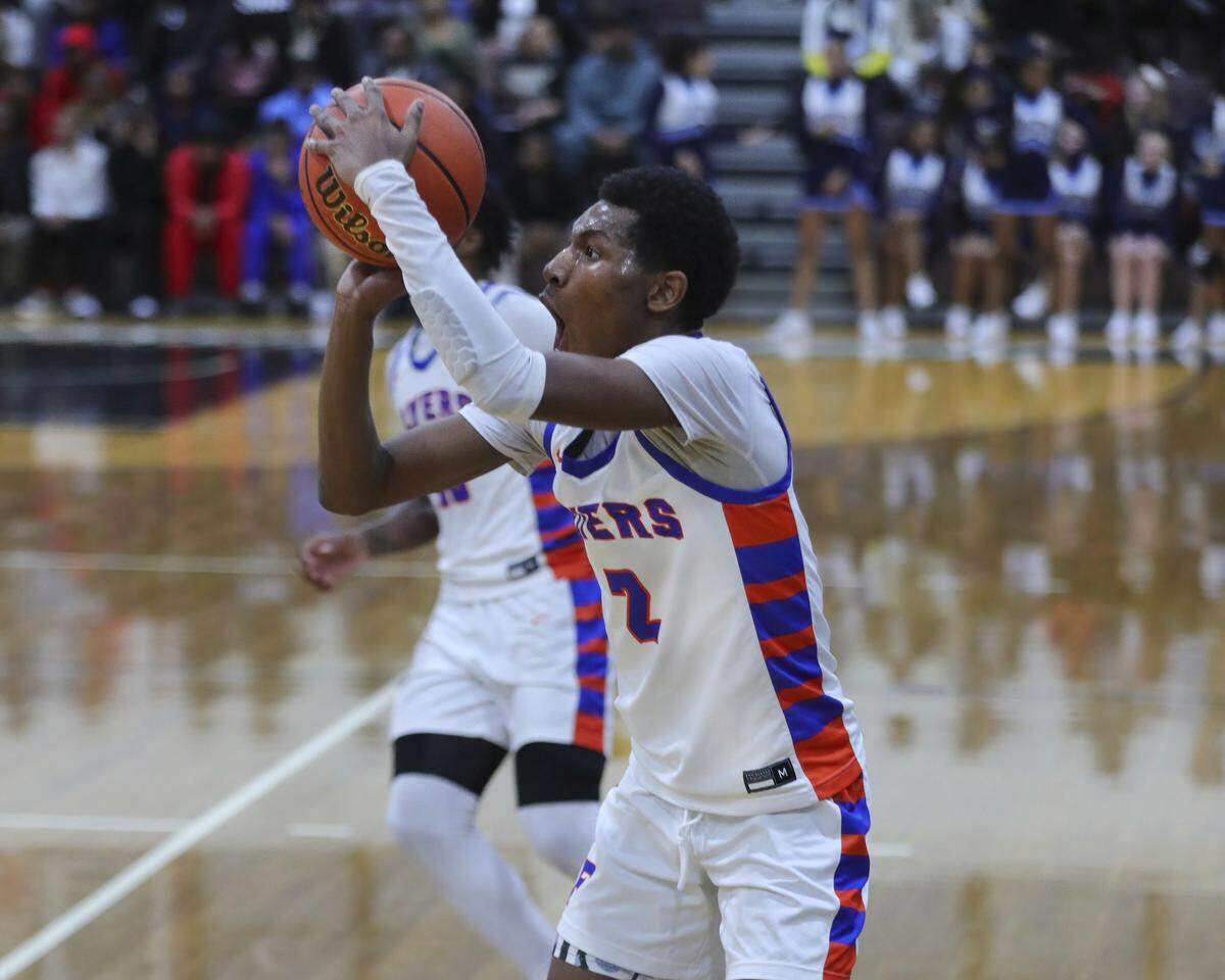 East St. Louis guard D’Necco Rucker takes a shot from three point range during Tuesday night’s Southwestern Conference game against Belleville East. The Flyers ultimately prevailed 72-71.
