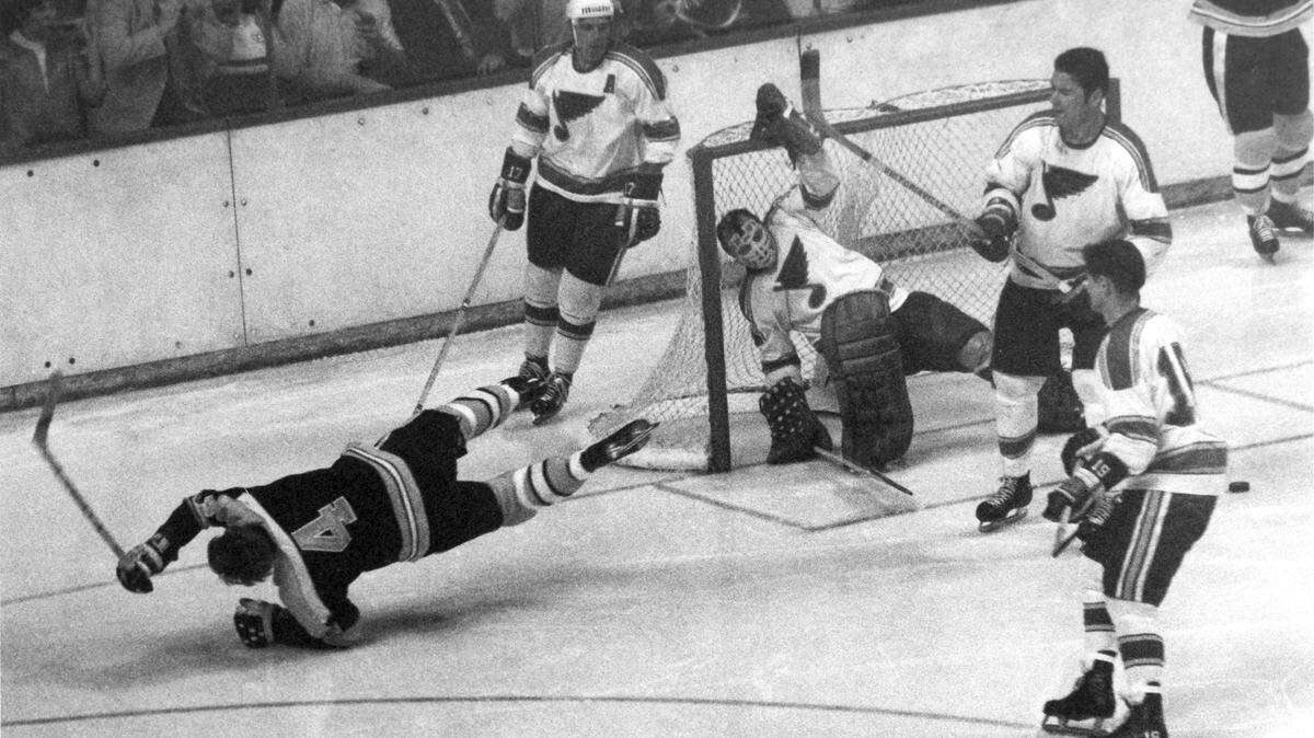 Bobby Orr of the Boston Bruins flips over as he is tripped after scoring the winning goal in sudden death overtime at Boston Garden, Ma., May 10, 1970.  Bruins beat the St. Louis Blues four straight games to bring the Stanley Cup to Boston for the first time in 29 years.  Blues goalie Glenn Hall is in the nets.  (AP Photo)