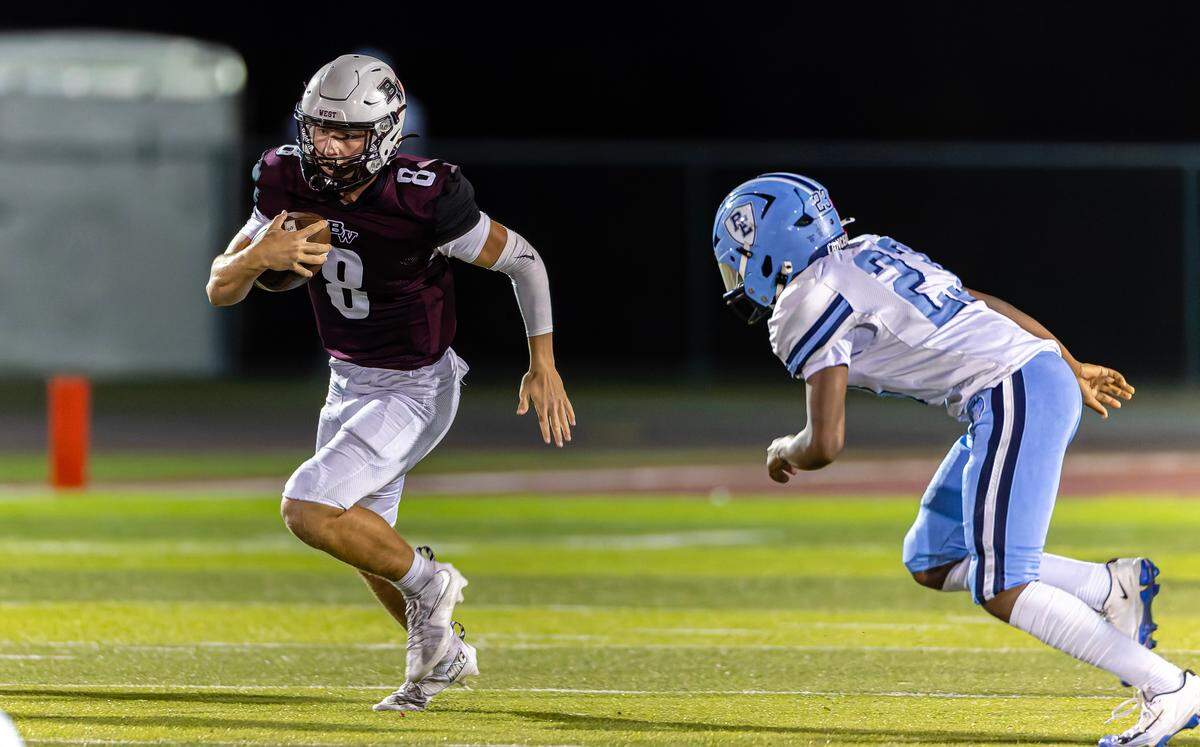 Belleville West’s Caiden Capell breaks away from East’s Trevon Smith to score a touchdown in the first quarter at Goalby Field Friday.