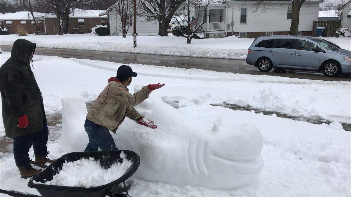Freddie Novosel, of Collinsville, does the “Baby Shark” dance for a car that stops at his home to find out what his snow sculpture would be. Novosel said he’s been making sculptures out of snow since the ’80s. Now, he builds them with his son.