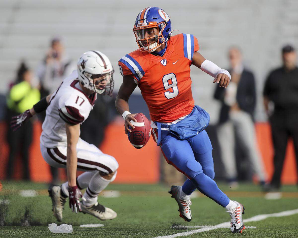 East St. Louis quarterback Robert Battle looks downfield for an open receiver during the IHSA Class 6A championship game against Prairie Ridge.