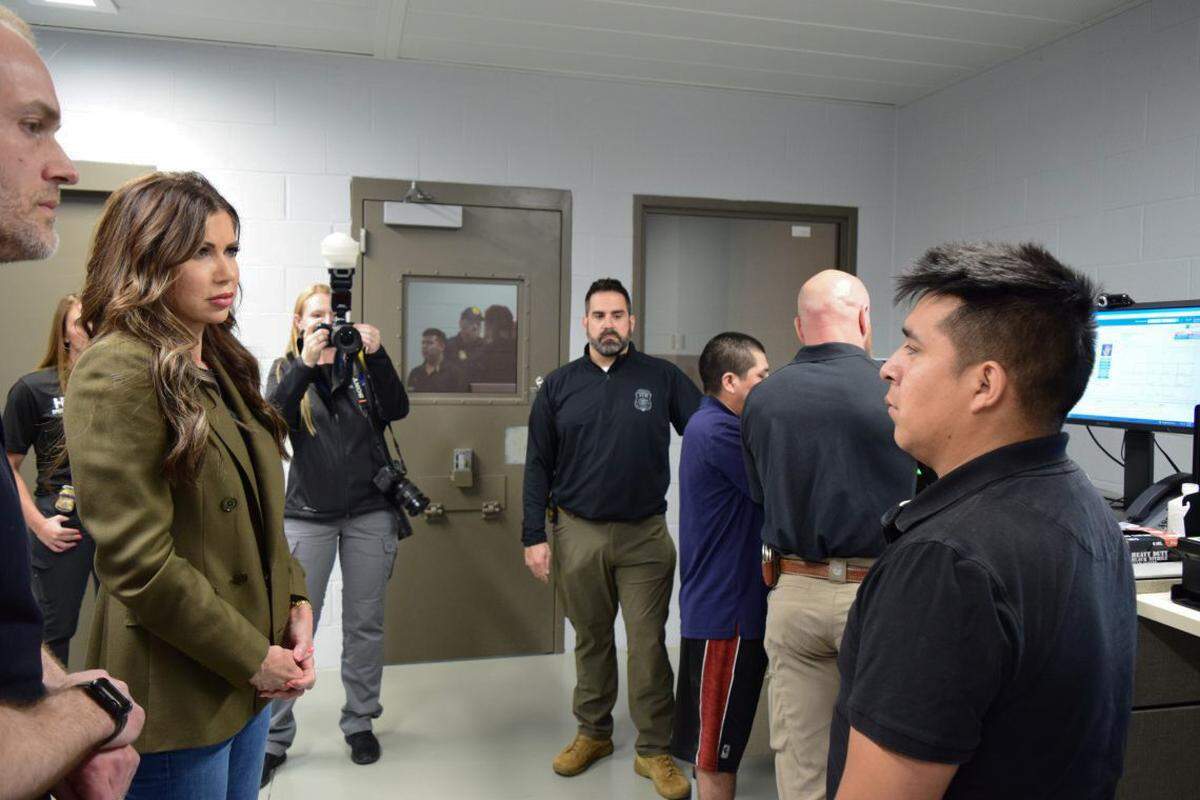 DHS Secretary Kristi Noem speaks with one of the two men being processed by ICE officials during her visit to Springfield.