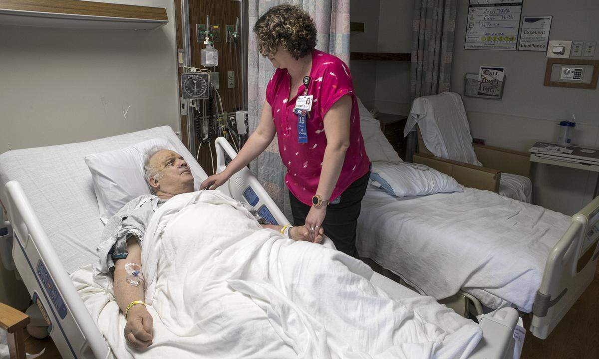 Kristin Atchison RN, speaks with Memorial Hospital patient Frank Austin. New Illinois legislation could force hospitals to maintain a specific patient to nurse ratio not based on care needs, but only on populaiton.
