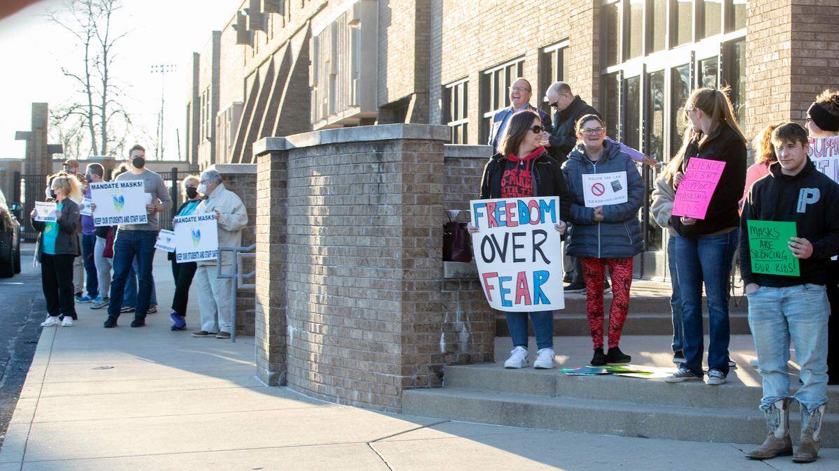 Groups for and against mask mandates stand outside of Collinsville High School before the start of the Collinsville School District 10 board meeting. The board voted to remove the mask mandate, but masks are still strongly recommended in the schools effective Feb. 15 2022.