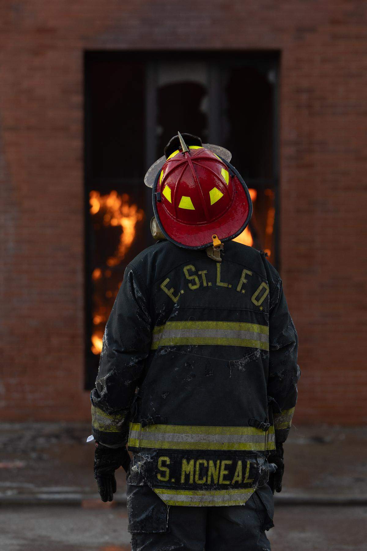 An East St. Louis firefighter stares on as a fire rages through a former lawyer’s office downtown.
