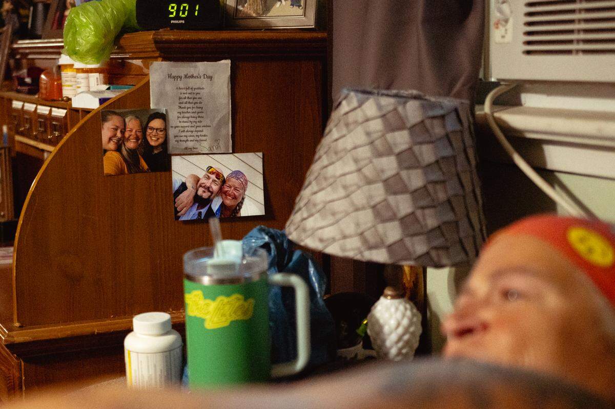 Photographs of Tina Weber’s daughters, Samantha and April, and her ex-boyfriend Mark Blaylock are displayed in her room on Friday, Aug. 16, 2024, in Collinsville, Illinois. “I like to see the things that I love when I wake up,” she said.