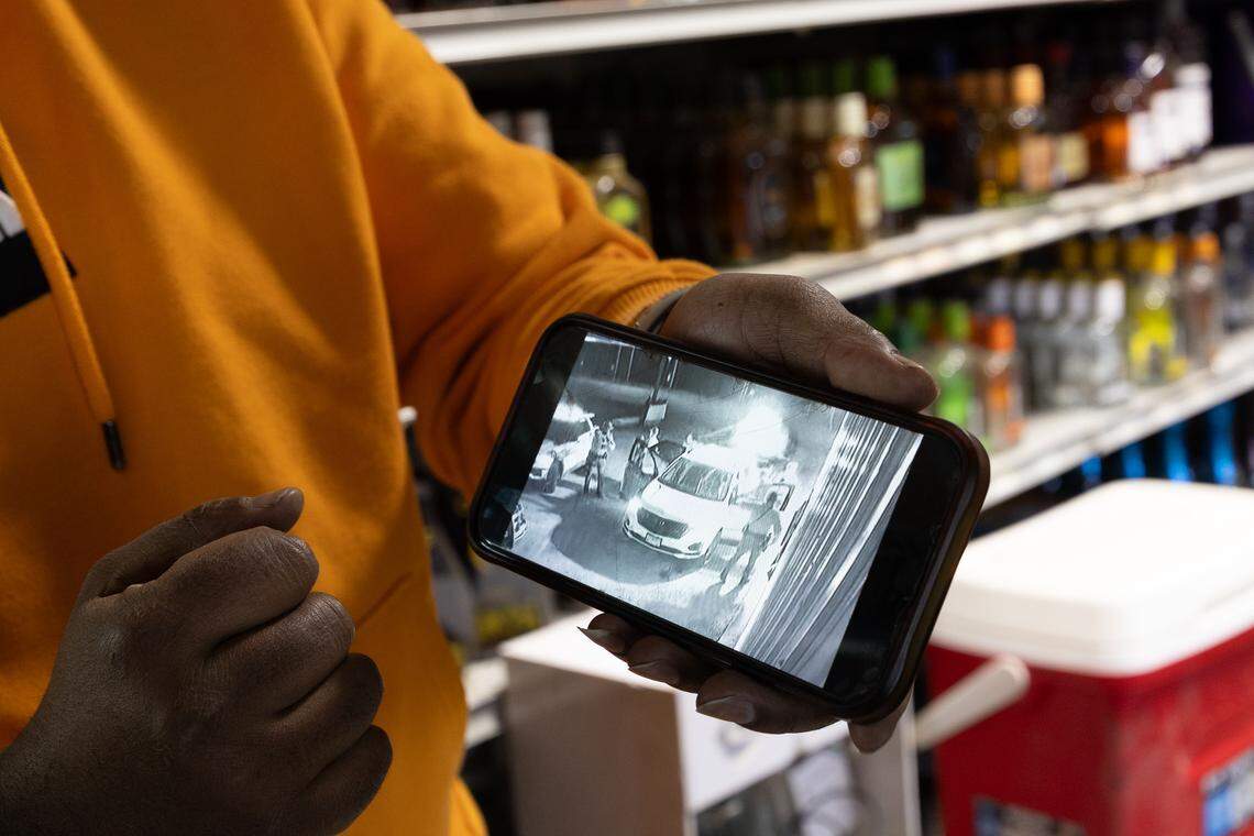 Said Mohamed, a manager at the OG Super Rainbow Liquor store in East St. Louis, holds a phone showing the security camera recording of a shooting that happened between Illinois State Police and a woman on Jan. 4 outside the store.