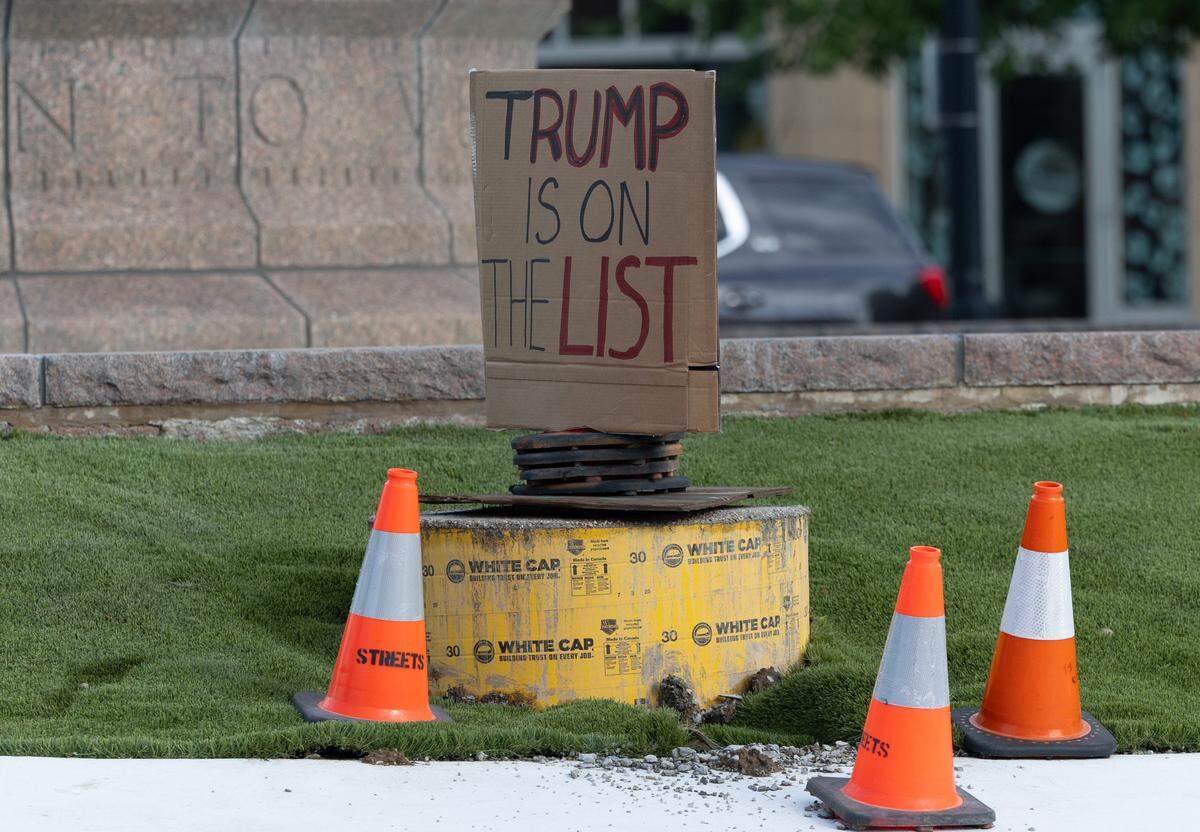 A sign in the middle of the Public Square roundabout reads “Trump is on the list,” referencing the administration’s handling of the Jeffrey Epstein files.
