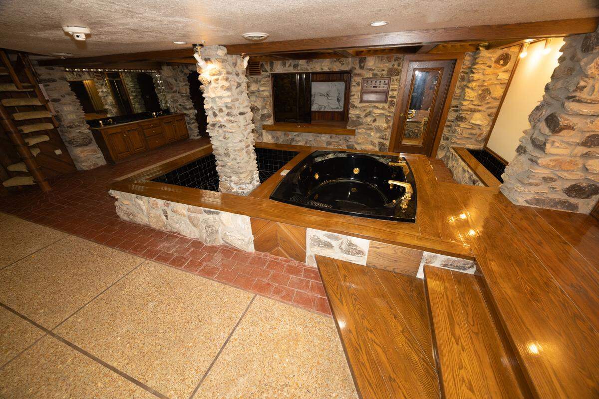 Inside of the spa room, where a jacuzzi tub and stone floors add a touch of relaxation that’s hard to match.