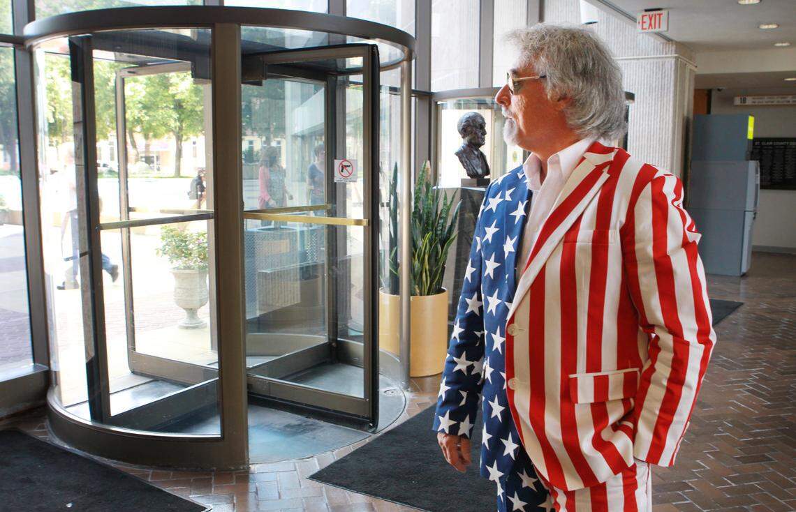 In this July 29, 2014, file photo, Bob Romanik waits on the first floor of the St. Clair County Building for county court in a red, white and blue Uncle Sam costume, minus the top hat, as a way of reminding the public, “If they can do this to me, they can do this to you.”