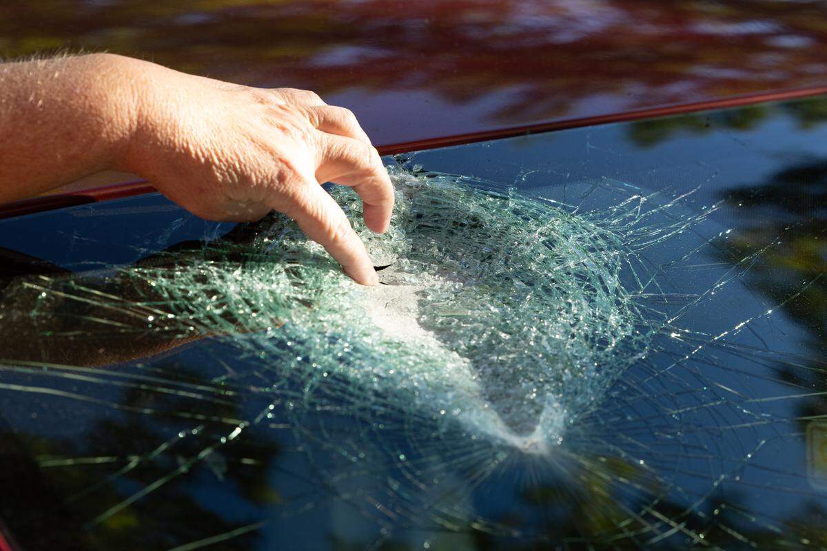 Brandi Matheis of O'Fallon points to the spot on the windshield of where a large rock struck her ex-husband’s car. The damage occurred when she was driving the car south on Interstate 255 where the highway crosses Illinois 163 on the night of Oct. 6, 2025.