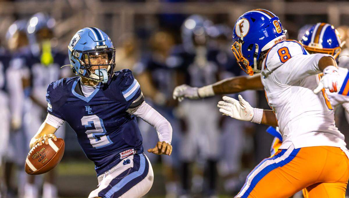 Belleville East quarterback Kayden Wood looks downfield for an open receiver while under pressure from the East St. Louis defense Friday.