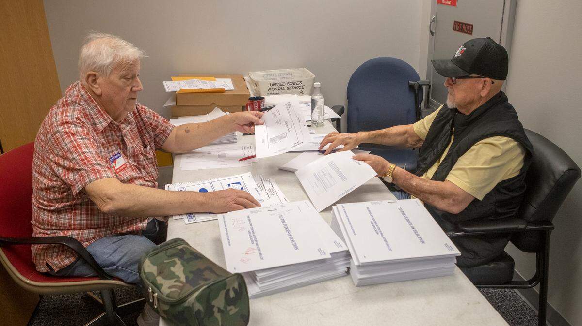 Election judges John Huff, a Democrat, and John Hubbard, a Republican, verify vote by mail ballots at the St. Clair County Clerk’s office. Approximately 13,000 mail-in ballots had been received as of Thursday, Nov. 3. St. Clair County Clerk Thomas Holbrook said that vote by mail was up in this election in comparison to the 2018 election, which also included the governor’s race, because Illinois voters can permanently register to vote by mail.