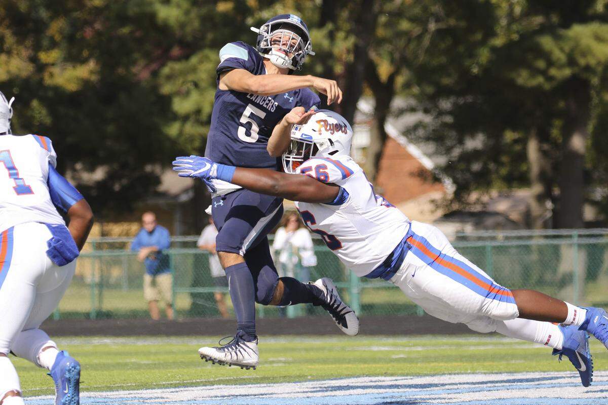 Belleville East’s Lucas Maue gets a pass off while being hit by the East St. Louis’ Kendrick Scarbrough during a game in 2019. Both teams kicked off the 2022 season this weekend, with the Lancers playing Friday night and the Flyers scheduled to play Saturday night.