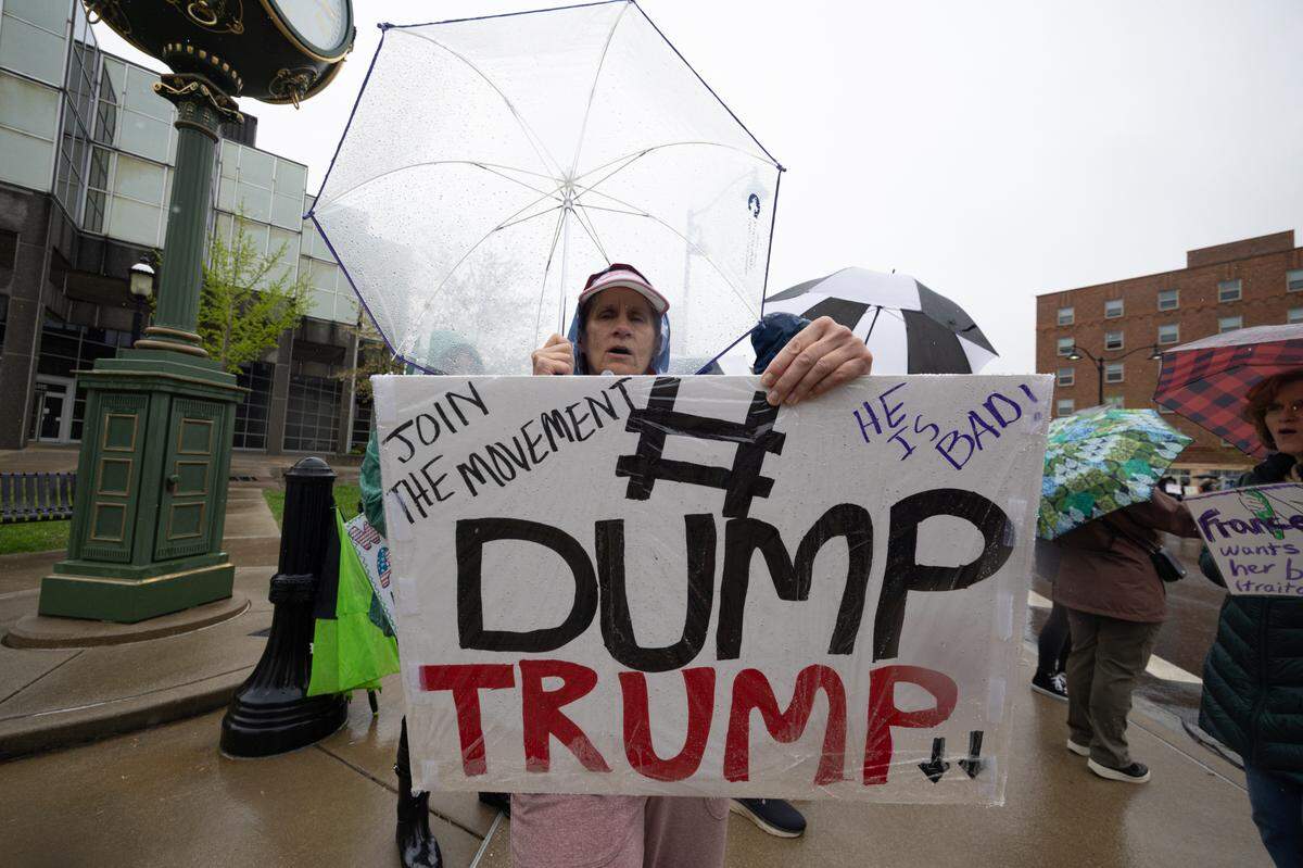 A protestor holds up a sign saying #DumpTrump during a protest on Belleville’s Public Square Saturday..