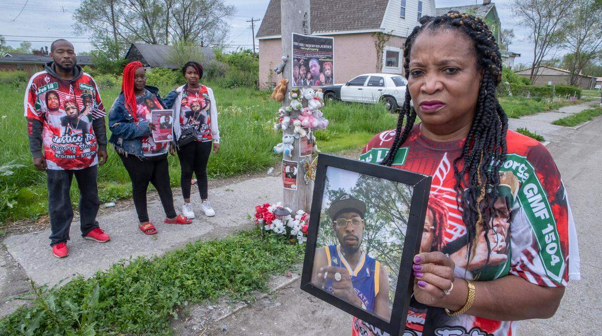 La’Tatia Stewart holds a photo of her son Gregory Stewart. Her children, Paul Stewart Jr and Therica Dowden stand with Danaysia Stewart her granddaughter and daughter of her son Gregory Stewart.