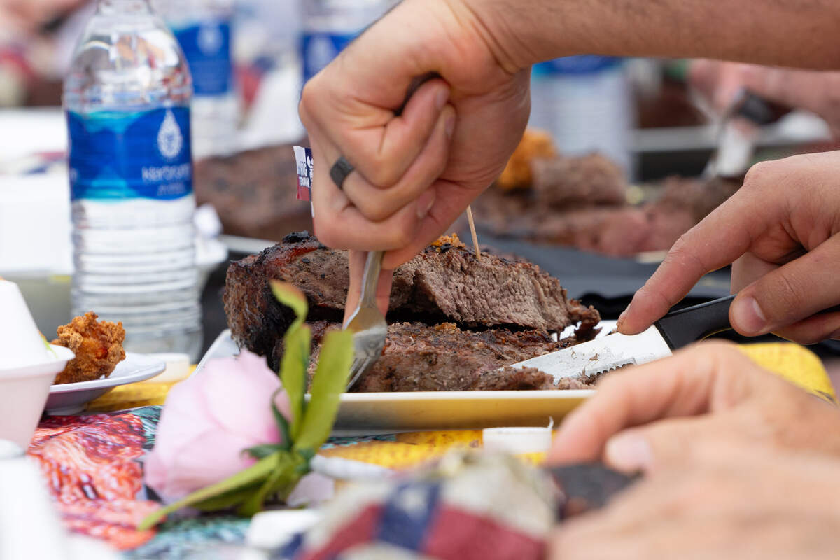 A participant cuts into a four-and-a-half pound steak at the start of the Big Texan Steak Ranch challenge.