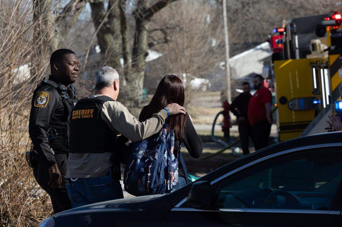 First responders escort a victim of a house fire at 19 St. Gregory Dr. in Cahokia Heights, Ill. from outside the designated safe zone after she arrives to a scene of chaos after school on Feb. 23, 2024.