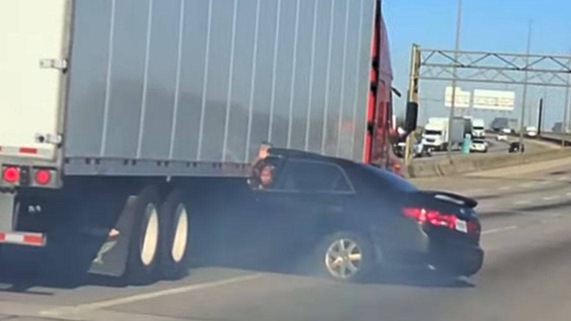 A driver waved out their window as their car was being dragged by a semi on an interstate in Illinois.