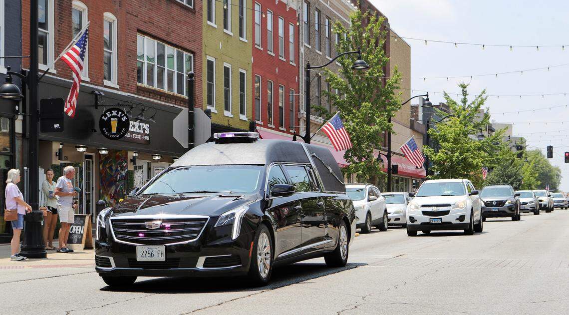 A Renner Funeral Home hearse carrying the casket of former Belleville Mayor Mark Eckert drives through businesses on East Main Street on its way to Walnut Hill Cemetery on Monday.