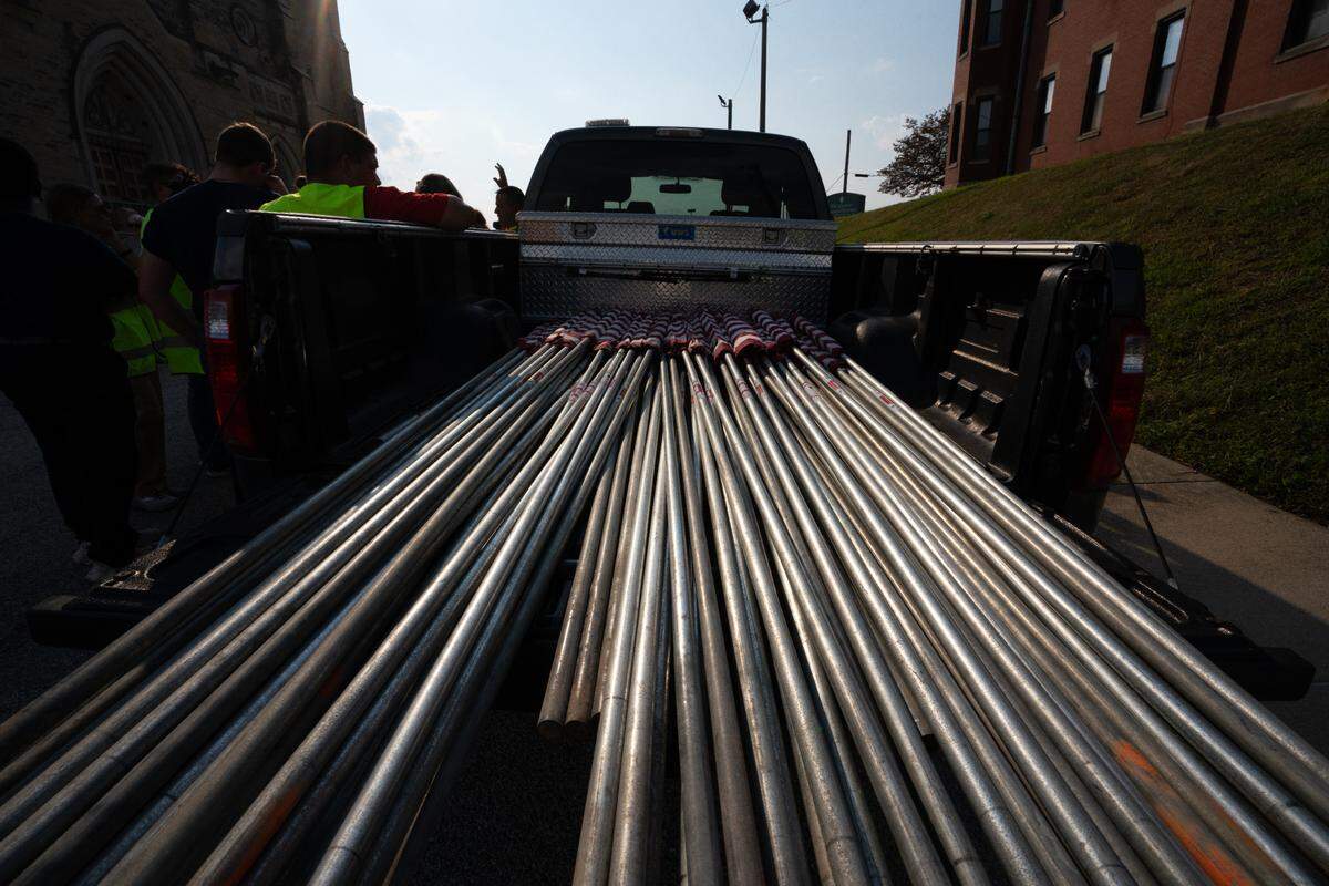 Flags brought to be placed along a funeral route as part of a homecoming for a fallen servicemember on Sept. 21, 2023.