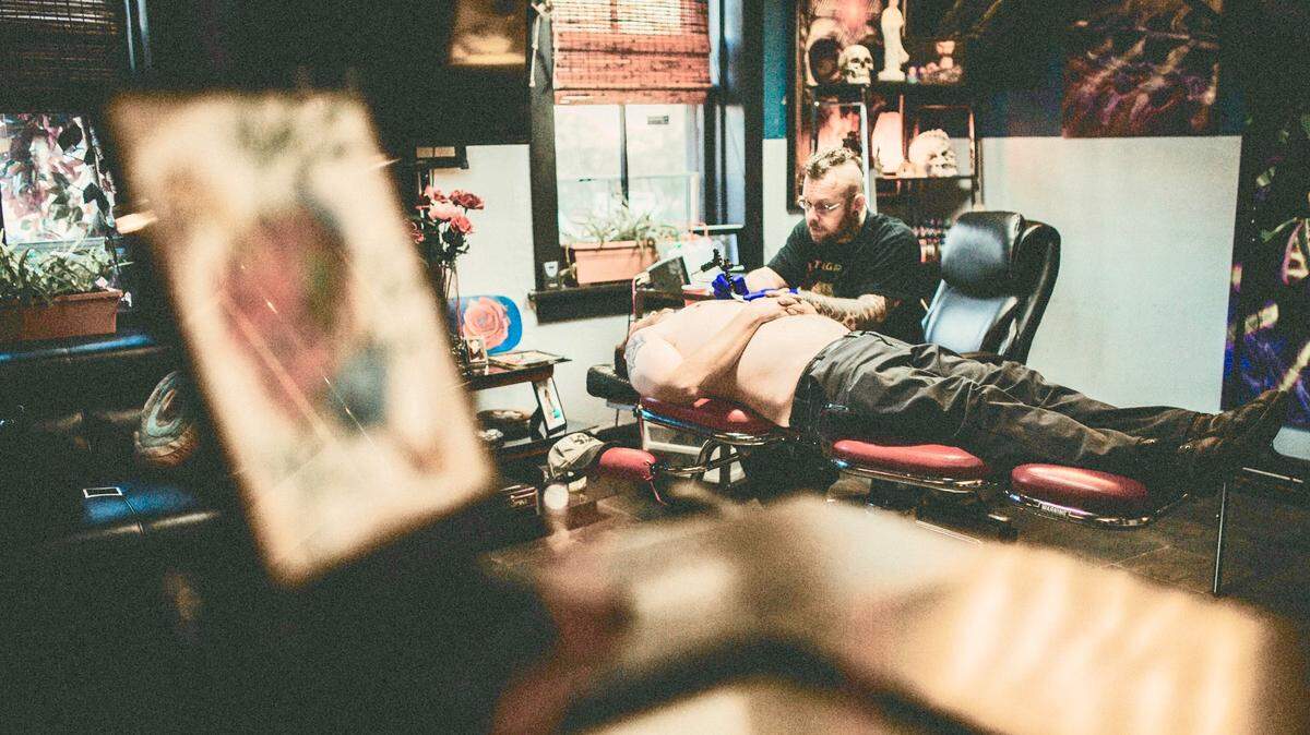 Jason Wilson, longtime owner of Integrity Tattoos in Belleville, applies an image to a customer’s chest. He hopes to move his business from North Illinois Street to Main Street now that a city ordinance allows it.