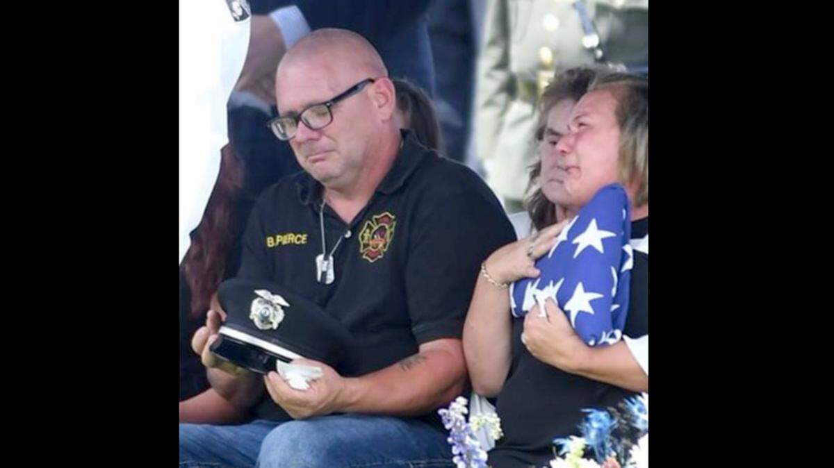 Brian Pierce Sr. and Tammy Pierce attend the internment for their son, Brian Pierce Jr., a Brooklyn Police officer who was killed on the McKinley Bridge on Aug. 4 when he was struck by a motorist fleeing police.