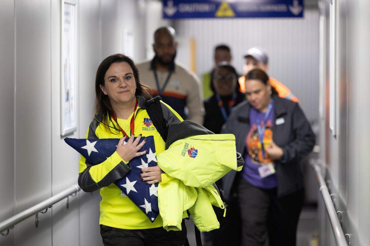 A representative from Greater St. Louis Honor Flight carries the flag that was given to the group at the Lincoln Memorial in Washington, D.C.