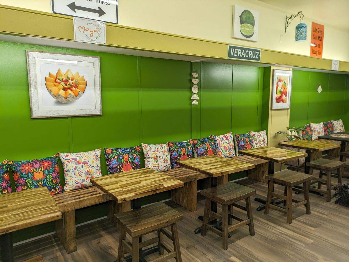 Bench seating lined with colorful pillows at Maya