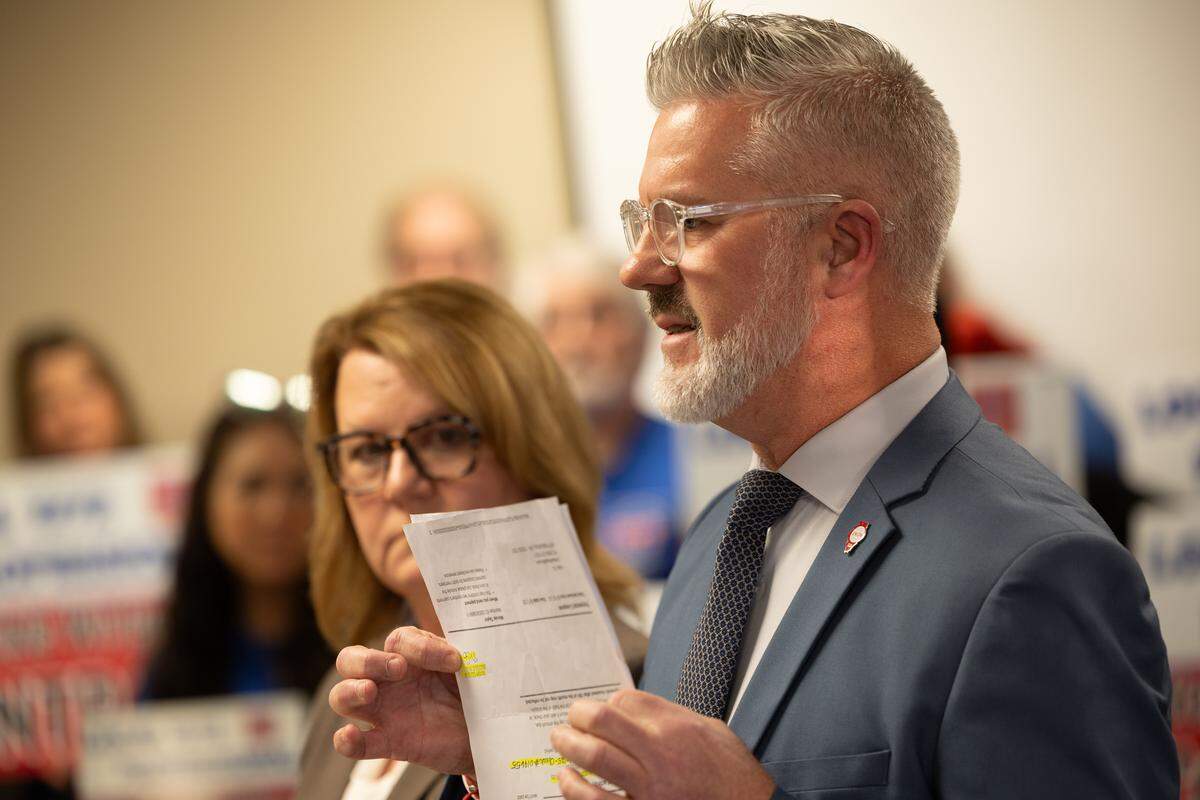 Ray Roskos and Wendy Lochmann, representatives of local 1272, The Cahokia Federation of Teachers, display documents detailing the school’s payroll, which they allege include nepotism hires that do not do perform actual work.
