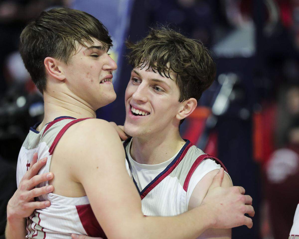 Gibault’s Kaden Augustine and Kameron Hanvey celebrate after Saturday’s IHSA Class 1A state championship game against Scales Mounds at the State Farm Center on the campus of the University of Illinois. Gibault ultimately prevailed 65-45 to claim the state title.
