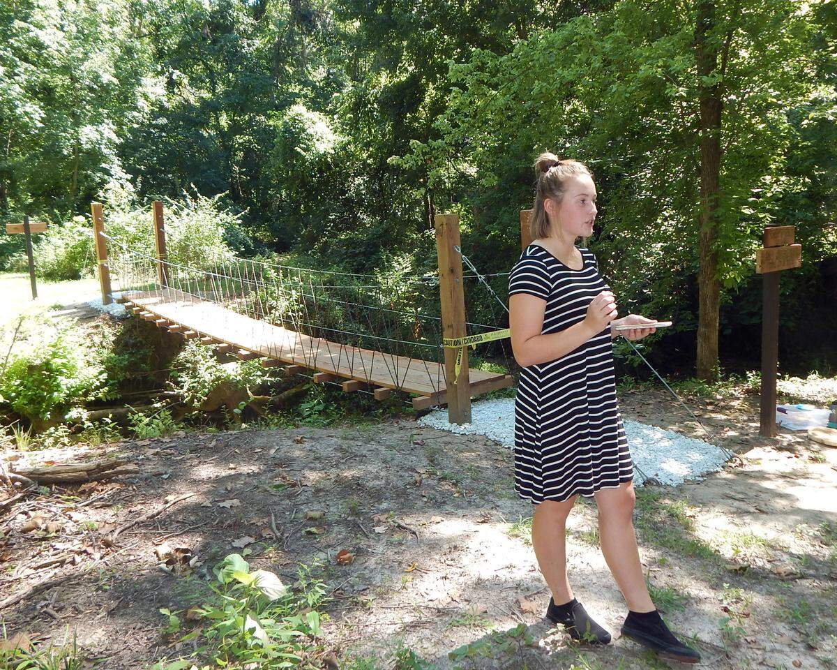 Leah Walton dedicating the bridge she built at Camp Torqua with campers at GSSI STEM Day Camp in the background.