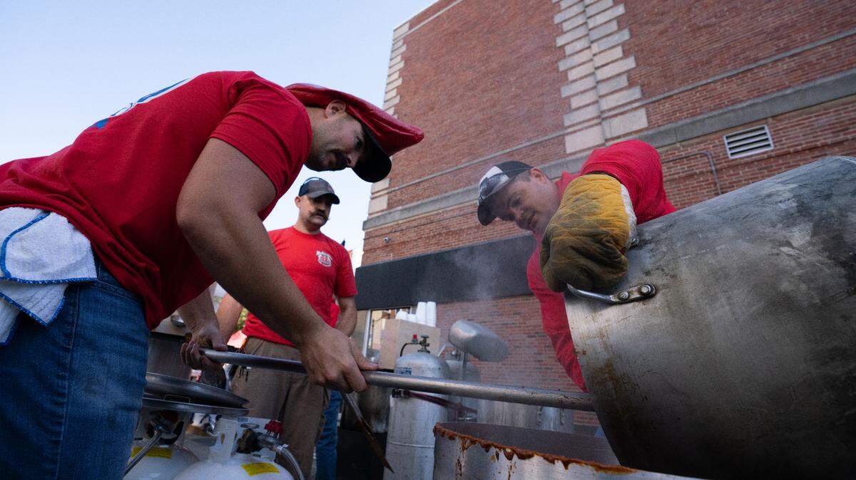 Firefighters transfer contents of one pot to another during last year’s Belleville Chili Cook-Off.