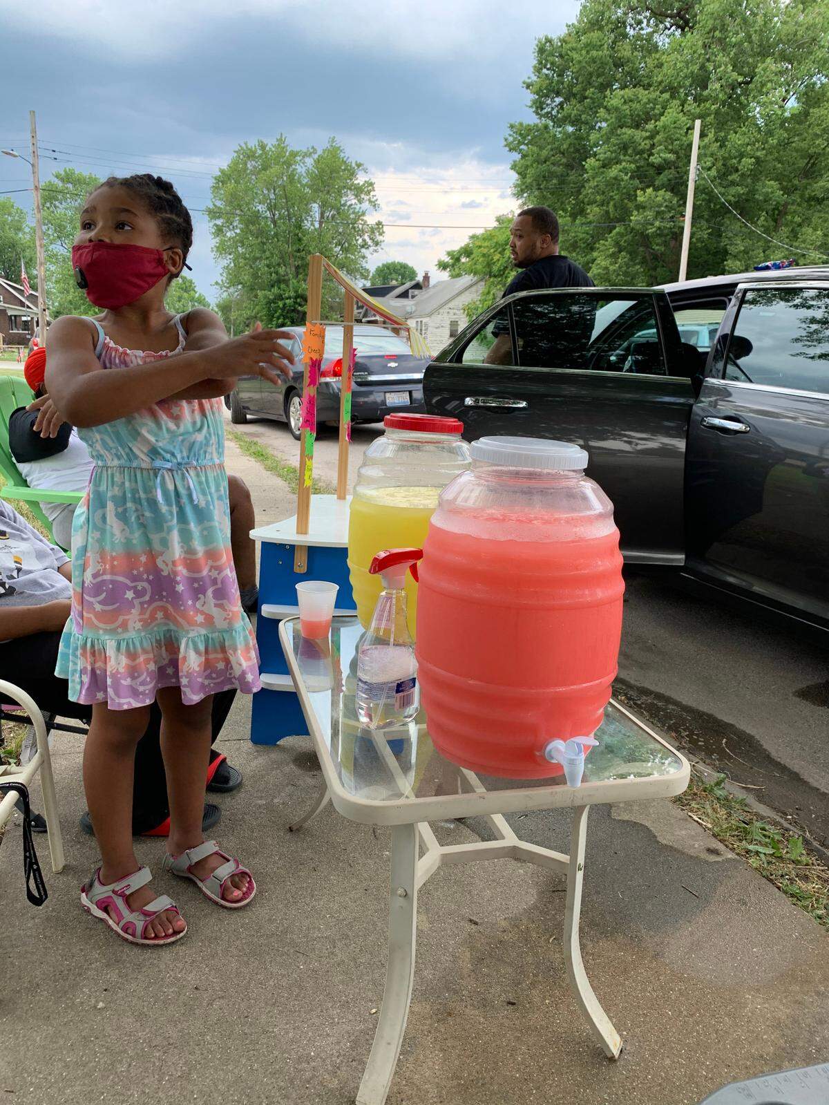 Zoe Howlett, 6, works the lemonade stand. Her mother Tiara Moore and their family are working together to have a lemonade stand and movie night in their community.