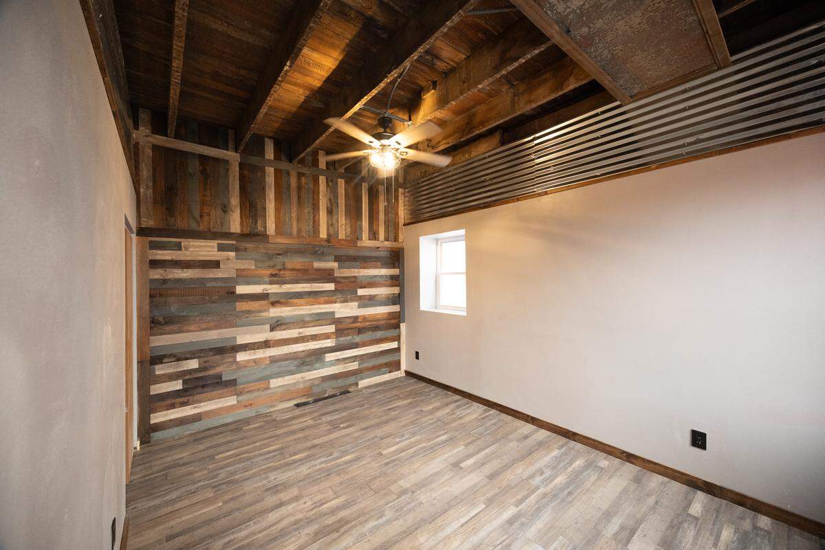 The bedroom on the second floor features laminate flooring and walls.